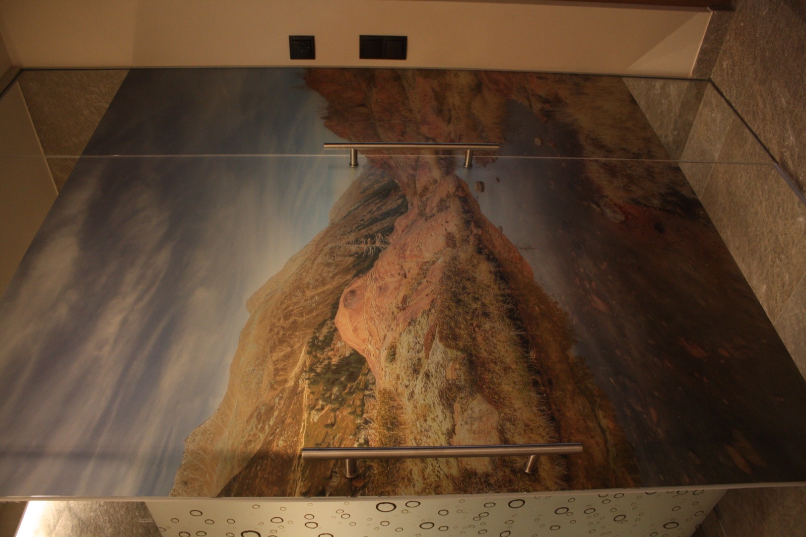 Glasfläche mit bedrucktem Bergmotiv über dem Waschtisch