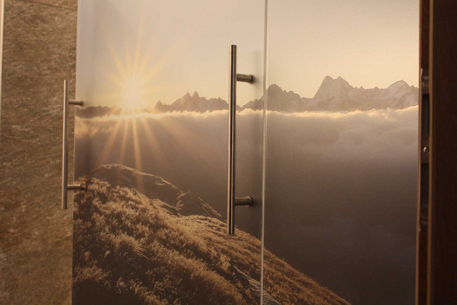 Glastür mit bedrucktem Bergpanorama und Sonnenaufgang