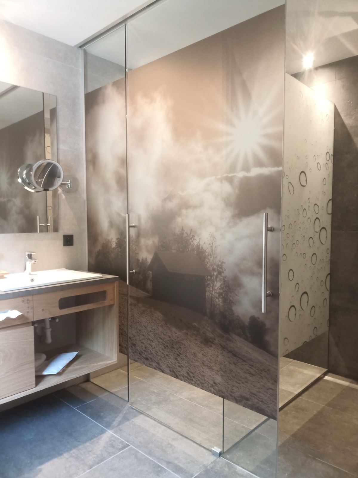 Duschabtrennung mit bedrucktem Nebelmotiv im Badezimmer