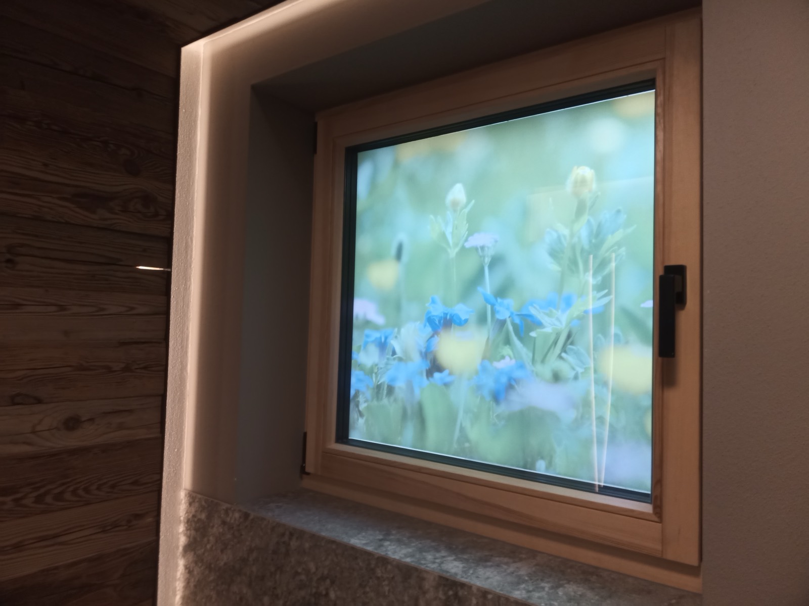 Holzfenster mit bedruckter Blumenwiesen-Folie als Sichtschutz