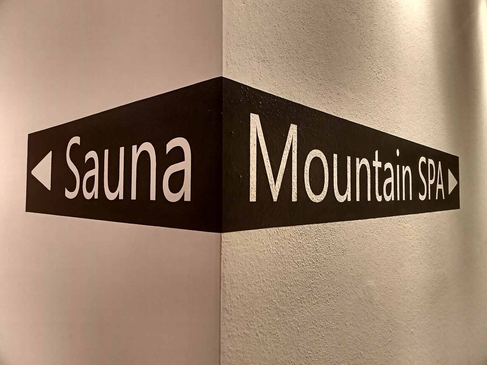 Wegweiser Sauna und Mountain SPA an einer Gebäudeecke